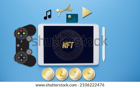 A picture of tablet with NFT and maze symbol. Symbol of music, image, vector and video. Game controller insight and cryptocurrency in line. Non Fungible Token and item can be convert concept.