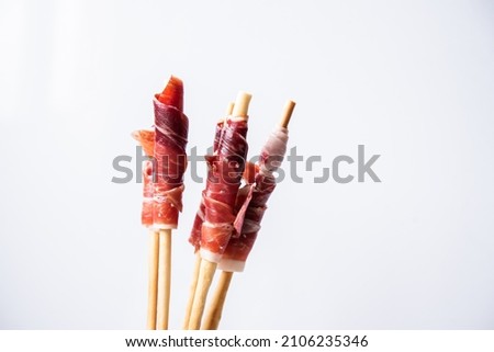 grissini with acorn-fed Iberian ham, on white background, Spanish tapa, for events, dinners or celebrations, Royalty-Free Stock Photo #2106235346