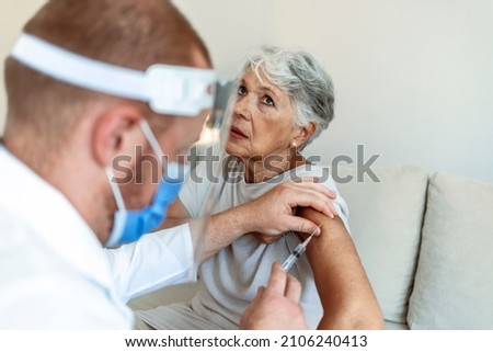 Cropped shot of a young doctor giving a senior woman a vaccination. Virus protection. Doctor giving injection to patient at home, close up. Vaccination day. Healthcare and medicine concept.