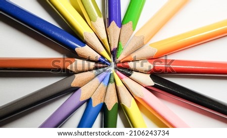 Different multicolor pencils converge on white background. Isolated close up macro shot. 