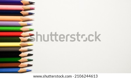 Color pencils border on white background. Isolated closeup shot with space for copy.
