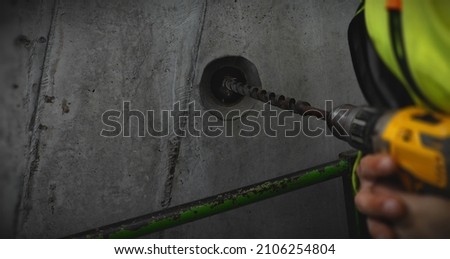 wall drill worker with drill, worker holding drill, yellow neon work uniform, photography in motion, mechanics industry work and construction work
