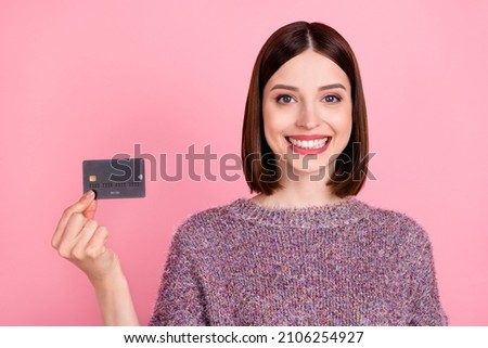 Photo of cheerful positive lady demonstrate plastic credit card wear knitted sweater isolated pink color background