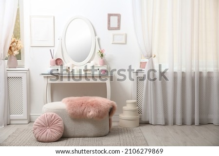 Dressing table with decor near white wall in room