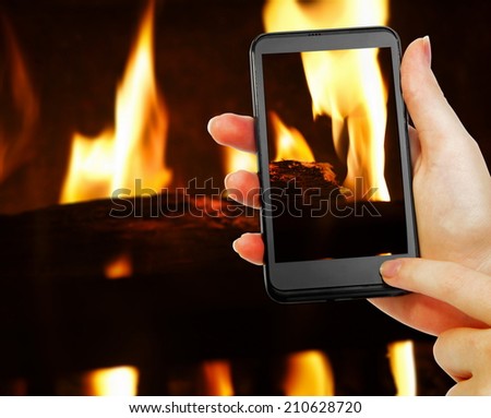 phone in hand with fireplace picture