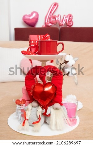 Home decorating ideas for Valentine's Day. Candy bowl decorated with gnomes, cup, candles and gift boxes