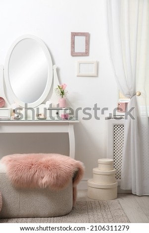 Dressing table with decor near white wall in room