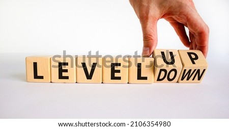 Level up or down symbol. Businessman turns cubes and changes concept words level down to level up. Beautiful white table, white background. Business and level up or down concept. Copy space.