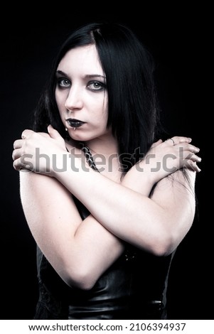 Pretty seductive gothic girl posing over dark background Royalty-Free Stock Photo #2106394937