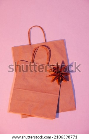Pink lit two flat paper bags with rope handles and origami star. Eco friendly compostable packaging.