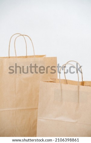 Close up cropped image of two brown paper bags with rope handles over white background. Eco friendly compostable object.