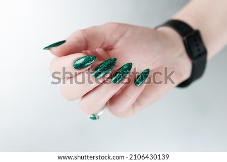 Women's hands with long nails and bright green manicure. 