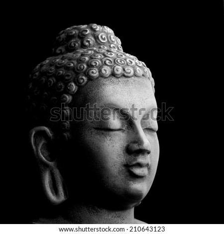Buddha portrait isolated on black; monochrome