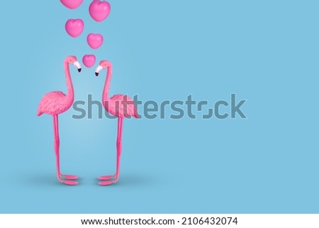 Creative fun concept with a couple of flamingos in love on pastel blue background. Minimal spring or summer Holiday love concept. Copy space