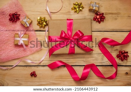 Gift boxes with satin ribbons on a wooden background. The concept of Valentine's Day, Mother's Day and Birthday. Paper hearts and bows.