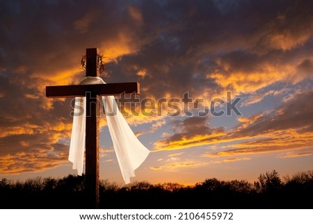 This dramatic sunrise lighting and Easter Cross makes a great Easter photo illustration of Jesus dying on the cross and rising again. Royalty-Free Stock Photo #2106455972