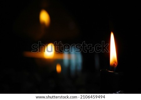 Close up of burning candles on dark background.