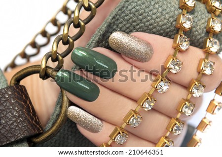 	  Green manicure with a brilliant gold lacquer on oval shaped nails. Royalty-Free Stock Photo #210646351