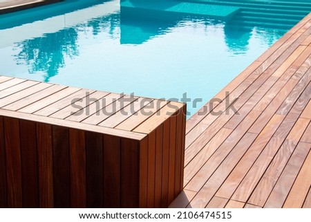 Hardwood ipe pool deck on direct sun heat, summer swimming pool decking design idea Royalty-Free Stock Photo #2106474515