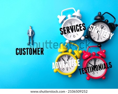 Miniature people and colored clock with text about customer concpet on a blue background.