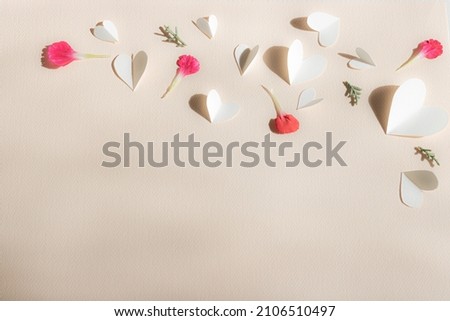 Vaaalentine's Day, small cut out white hearts, pink petals and sprigs of juniper scattered on peach vintage paper background, copy space