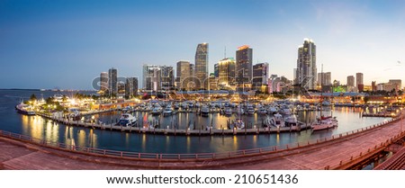 Miami city skyline panorama at twilight with urban skyscrapers, marina and bridge