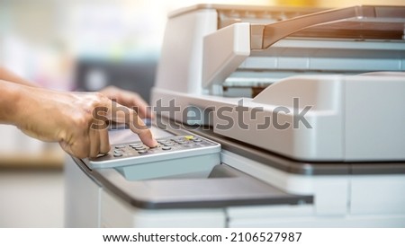 Copier printer, Close up hand office man press copy button on panel to using the copier or photocopier machine for scanning document printing a sheet paper and xerox photocopy. Royalty-Free Stock Photo #2106527987