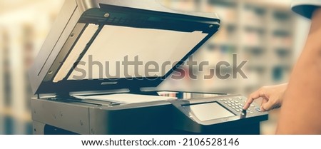 Copier printer, Close up hand office man press copy button on panel to using the copier or photocopier machine for scanning document printing a sheet paper and xerox photocopy. Royalty-Free Stock Photo #2106528146