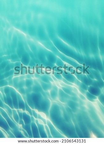 Blur​ abstract​ of​ surface​ blue​ water. Abstract​ of​ surface​ blue​ water​ reflected​ with​ sunlight​ for​ background. Closeup photo​ of blue​ water.​ Water​ splashed​ use​ for​ graphic​ design.