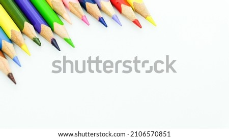 Color pencils border pattern on white background for back to school. Isolated closeup shot with space for copy.
