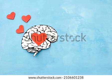 hearts fly out of the brain of a man in love from paper on a blue background Royalty-Free Stock Photo #2106601238