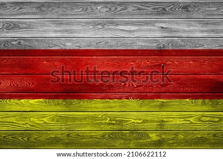 The national flag of Ossetia
 is painted on a camp of even boards nailed with a nail. The symbol of the country.