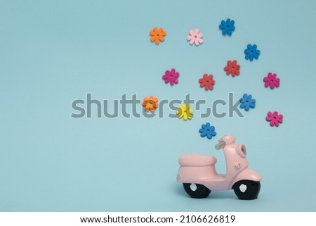 colorful flowers on a blue background and a pink motorbike with copy space. Hollydays. Valaentines day 