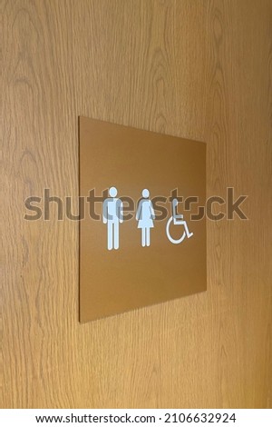 Brown wooden sign of toilets.