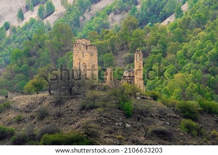Selective focus. Stone ancient monastery on the green mountain. Memorial complex Vatan, Sogratl village in Dagestan. Russia. Royalty-Free Stock Photo #2106633203