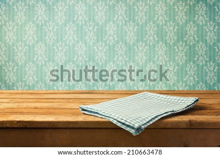 Tablecloth on wooden table over retro wallpaper