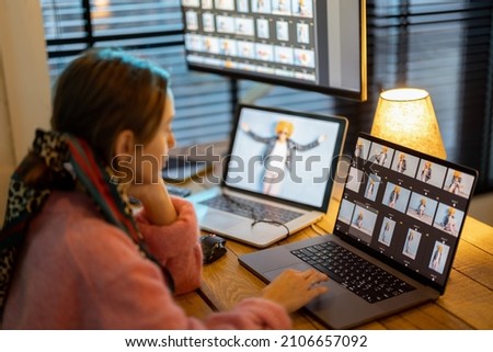 Young creative woman work on laptop and desktop computers editing photos at cozy home office. Portrait of female photographer at home workplace