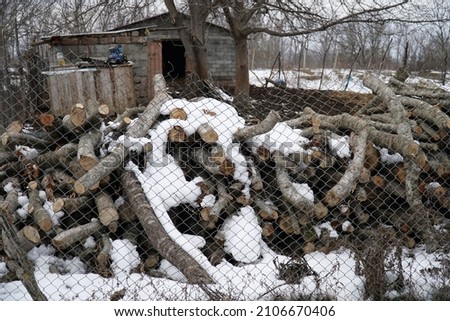 the wood for the stove is covered with snow in the village, winter preparation.