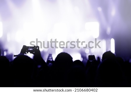 Silhouette of hands recording a concert with smart phones. Crowd of people using smart phones to photographing a concert
