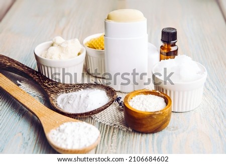 Making homemade deodorant stick with all natural ingredients concept. Wooden background. Ingredients: arrowroot powder, baking soda, beeswax, shea butter, essential oil, cornstarch, coconut oil. Royalty-Free Stock Photo #2106684602