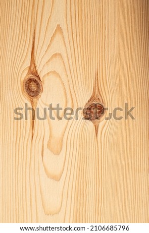 A pareidolia of a monster on a wooden board. the shape of the wood grain and knots form a strange face.
