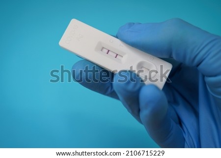 Closeup shot of a hand holding a positive antigen test