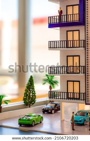 Toy house and cars, miniature residential area.