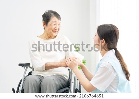 Asian caregiver and a senior woman at the room Royalty-Free Stock Photo #2106764651