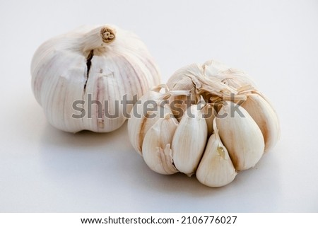 Two bulbs of garlic on a white background.