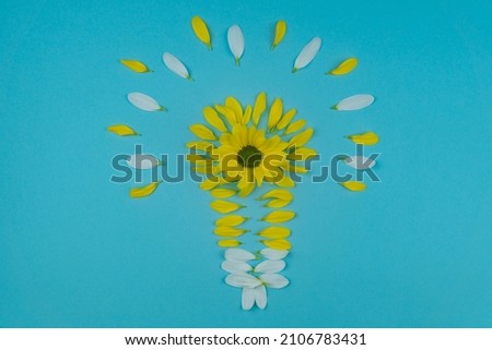 composition in the form of a light bulb from petals of yellow and white flowers and a yellow flower. picture is a good idea