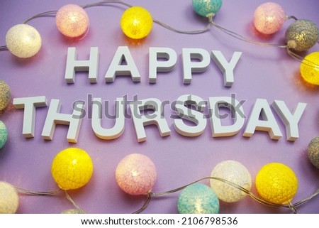 Happy Thursday alphabet letters with LED cotton balls on purple background