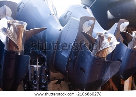 Three outboard motors mounted on the stern of a motor boat, bottom view. Royalty-Free Stock Photo #2106860276