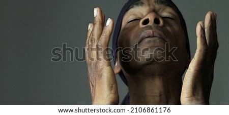 man praying to god with hands together on grey background 