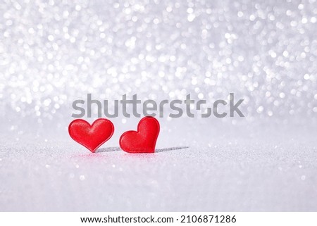 Red hearts on argent blurred abstract background with bokeh. San Valentine's day concept. Greeting card.